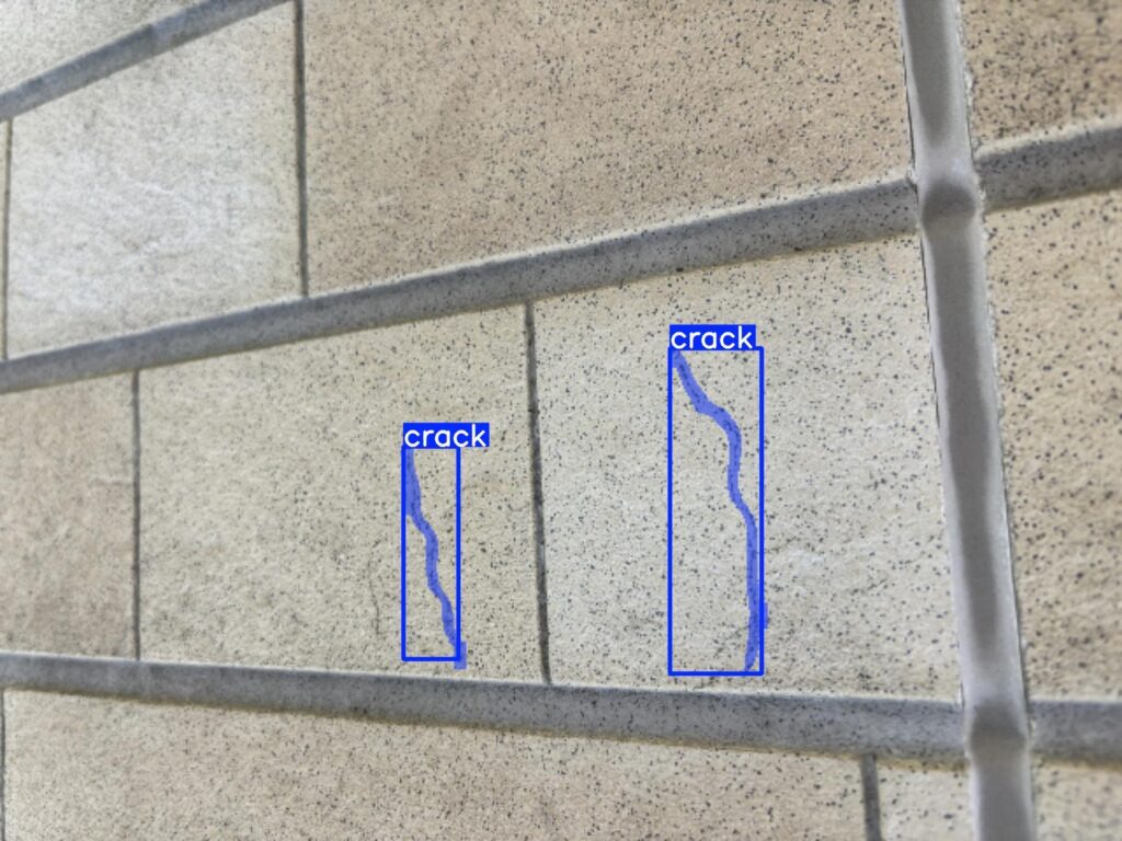 外壁のひび割れをAIが青い枠線で自動検出している画像